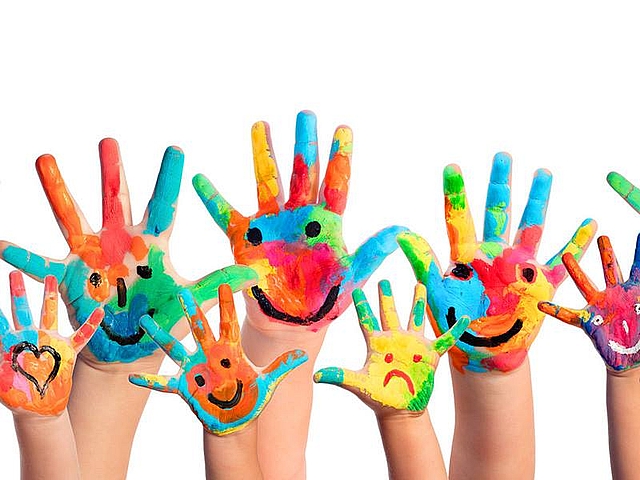 Mani di bambini colorate con sorrisi disegnati